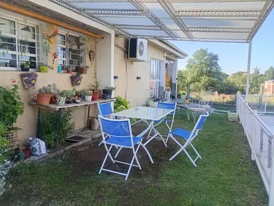a patio with a table and chairs on the grass at La Soñada in Villa Parque Siquiman