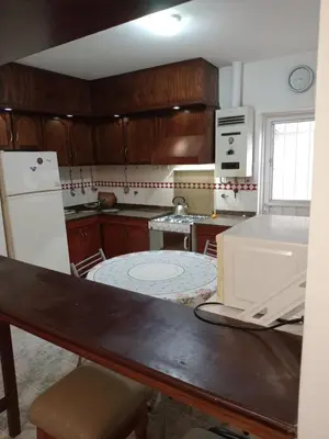 a kitchen with wooden cabinets and a white refrigerator at Complejo Alfa Iii in Villa Carlos Paz