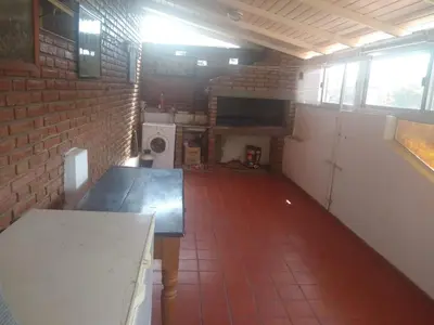 an empty room with a brick wall and a table at Complejo Alfa Iii in Villa Carlos Paz