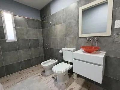 a bathroom with a toilet and a sink and a mirror at Depto Zenon para 3 personas in Pilar