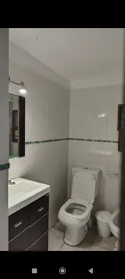 a white bathroom with a toilet and a sink at La Julianita in Villa Cura Brochero
