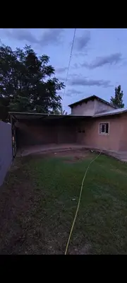 a house with a yard with a hose in front of it at La Julianita in Villa Cura Brochero
