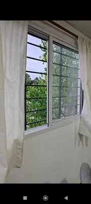 a window with white curtains in a room at La Julianita in Villa Cura Brochero