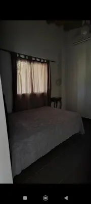 a bedroom with a bed and a window with a bedspread at La Julianita in Villa Cura Brochero