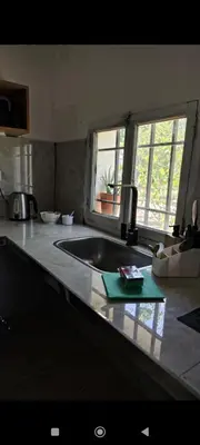a kitchen counter with a sink and a window at La Julianita in Villa Cura Brochero