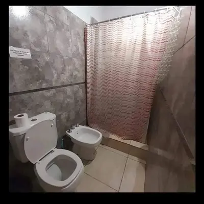 a small bathroom with a toilet and a shower at Cabañas Nuestro Valle Cura Brochero in Villa Cura Brochero