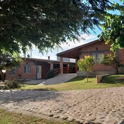 a brick house with a driveway in front of it at Cabañas Nuestro Valle Cura Brochero in Villa Cura Brochero
