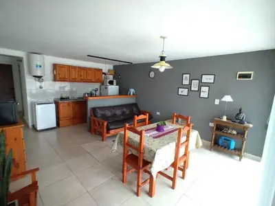 a kitchen and a living room with a table and chairs at El burrito cordobés in Villa Santa Cruz del Lago