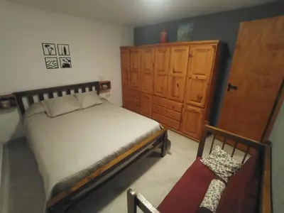 a bedroom with a bed and a wooden cabinet at El burrito cordobés in Villa Santa Cruz del Lago