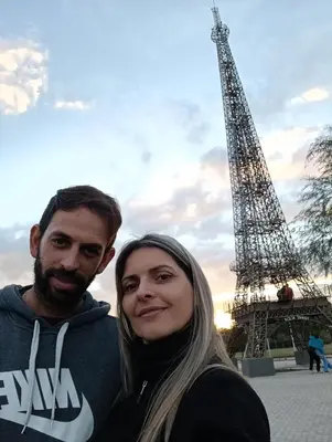a man and a woman standing in front of the eiffel tower at El burrito cordobés in Villa Santa Cruz del Lago