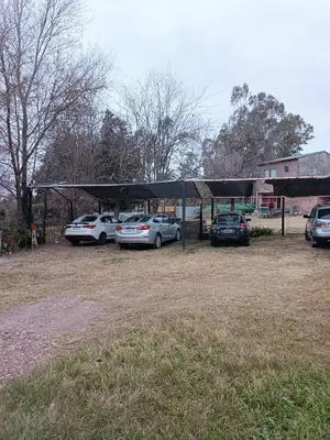 a parking lot with cars parked under a canopy at El burrito cordobés in Villa Santa Cruz del Lago