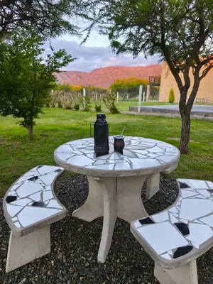 a picnic table with two benches and a jug on it at Atardeceres del dique in Cortaderas