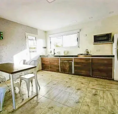 an empty kitchen with a table and a sink at Atardeceres del dique in Cortaderas