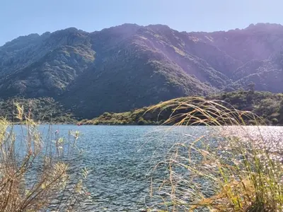 a large body of water with mountains in the background at Atardeceres del dique in Cortaderas