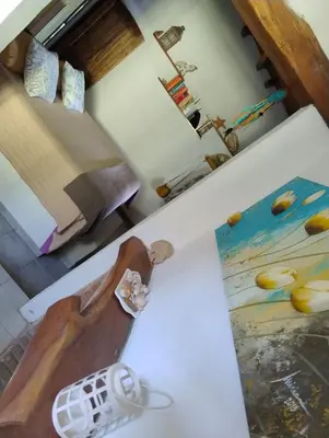 a room with a bed and a table with a painting at Linaje del Champaqui - San Javier in Villa de Las Rosas
