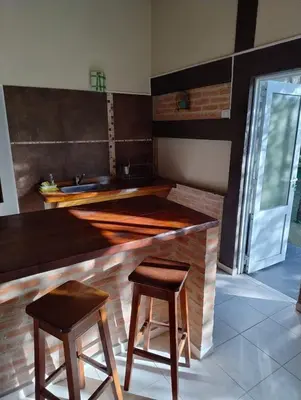 a kitchen with a counter with two stools and a sink at Linaje del Champaqui - San Javier in Villa de Las Rosas