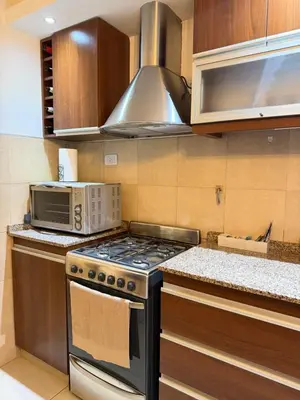 a kitchen with a stove and a microwave at Complejo Carde Housing in Villa Carlos Paz