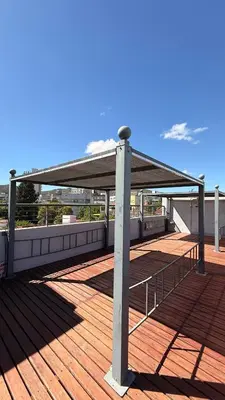 awning on top of a building with a wooden deck at Complejo Carde Housing in Villa Carlos Paz