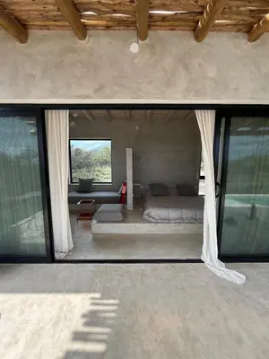 a bedroom with a bed in a room with windows at Casa Veta in La Porteña