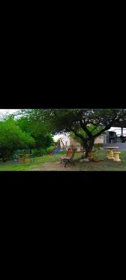 a park with a playground with a tree and a slide at Esencias Serranas in Cavalango