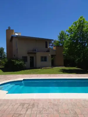 a swimming pool in front of a house at Las Tole - Potrero de Garay in La Estancia