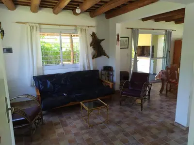 a living room with a black couch and chairs at Las Tole - Potrero de Garay in La Estancia