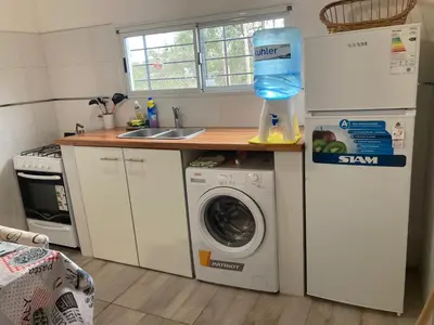 a kitchen with a refrigerator and a washing machine at cabaña el lago in San Ignacio