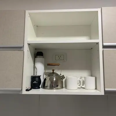 a cupboard with a tea pot and mugs in it at Güemes Córdoba Area in Cordoba
