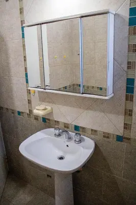 a bathroom with a sink and a mirror at Cabañas El DESCANSO in Cordoba