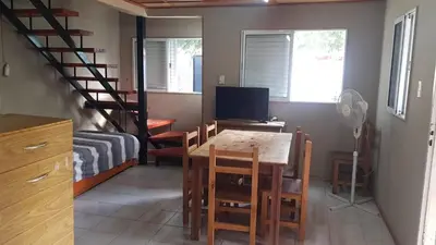 a room with a dining room table and a staircase at Cabañas El DESCANSO in Cordoba