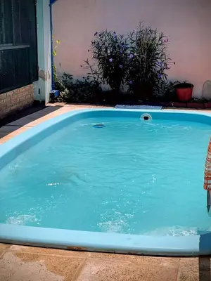 a swimming pool with blue water in a yard at La Casita del Tano con Pileta in Villa Carlos Paz