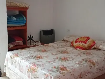 a bedroom with a bed with a flowered blanket at La Casita del Tano con Pileta in Villa Carlos Paz