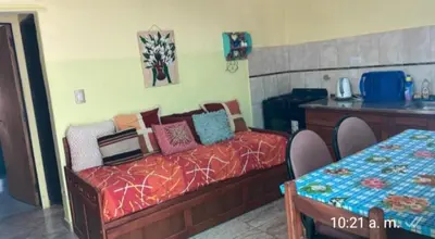 a bedroom with a bed and a table with chairs at La Casita del Tano con Pileta in Villa Carlos Paz