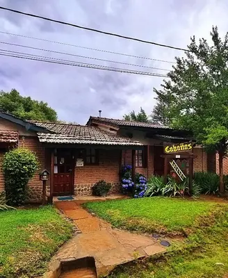 a house with a sign on the front of it at Cabañas Lorelei in Villa General Belgrano