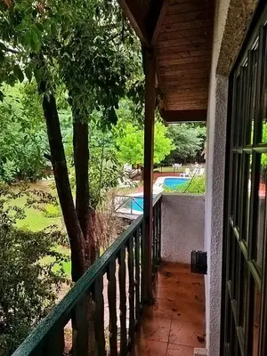 a porch of a house with a tree and a swimming pool at Cabañas Lorelei in Villa General Belgrano