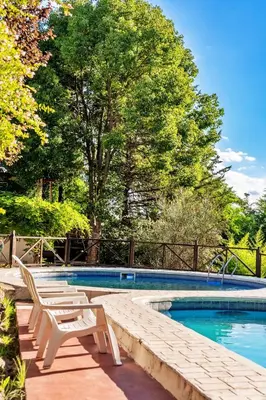a swimming pool with two lounge chairs next to it at Cabañas Lorelei in Villa General Belgrano