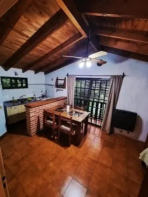 a kitchen with a wooden table in a room at Cabañas Lorelei in Villa General Belgrano