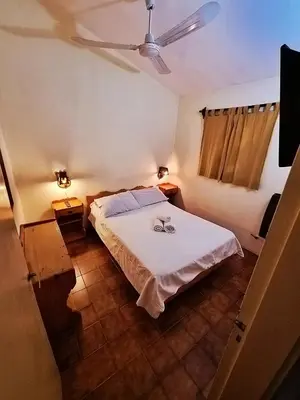 a bedroom with a bed and a ceiling fan at Cabañas Lorelei in Villa General Belgrano