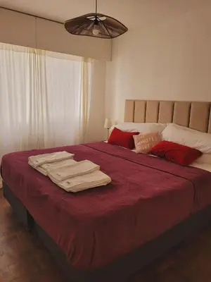 a bedroom with a large bed with red sheets at Departamento Patio Olmos in Cordoba