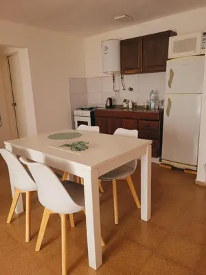 a kitchen with a white table and white chairs at Departamento Patio Olmos in Cordoba