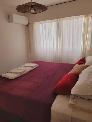 a bedroom with a large bed with red and white pillows at Departamento Patio Olmos in Cordoba