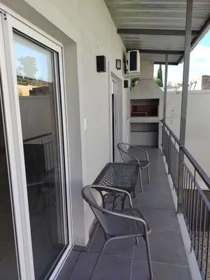 a balcony with chairs and tables on a building at Vila Aparts in Mina Clavero