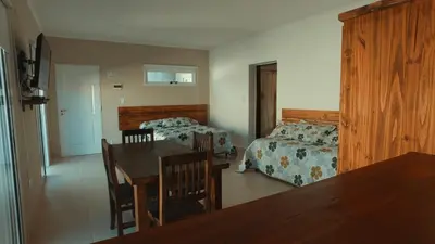 a bedroom with a table and a bed and a dining room at Vila Aparts in Mina Clavero