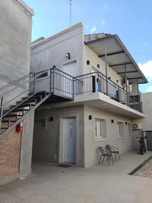 a building with a balcony with a staircase on it at Vila Aparts in Mina Clavero