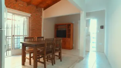 a dining room with a table and chairs and a television at Vila Aparts in Mina Clavero