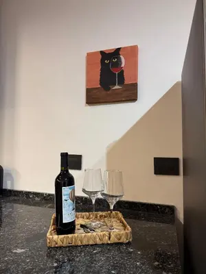 a bottle of wine and two wine glasses on a counter at Horse Petit Apartments in Cordoba