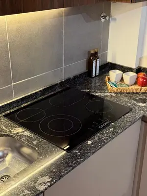 a kitchen counter top with a black stove top at Horse Petit Apartments in Cordoba