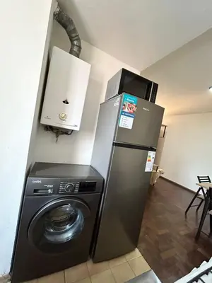 a kitchen with a refrigerator and a washing machine at Practico y tranquilo Departamento en Alberdi in Cordoba