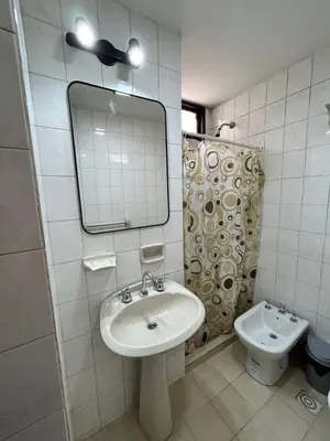 a bathroom with a sink and a mirror and a toilet at Practico y tranquilo Departamento en Alberdi in Cordoba