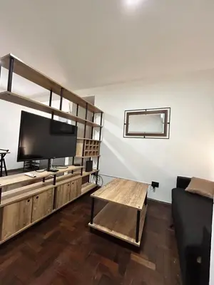 a living room with a flat screen tv and a table at Practico y tranquilo Departamento en Alberdi in Cordoba